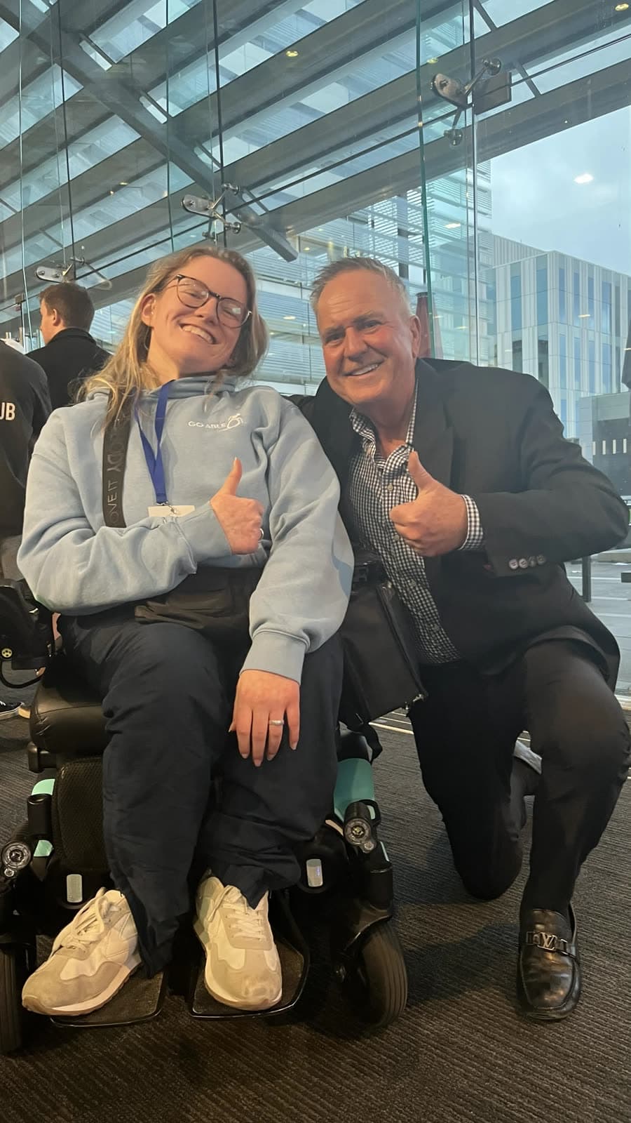 Daisy Hoe giving a thumbs-up beside a supporter, wearing a Go Able hoodie